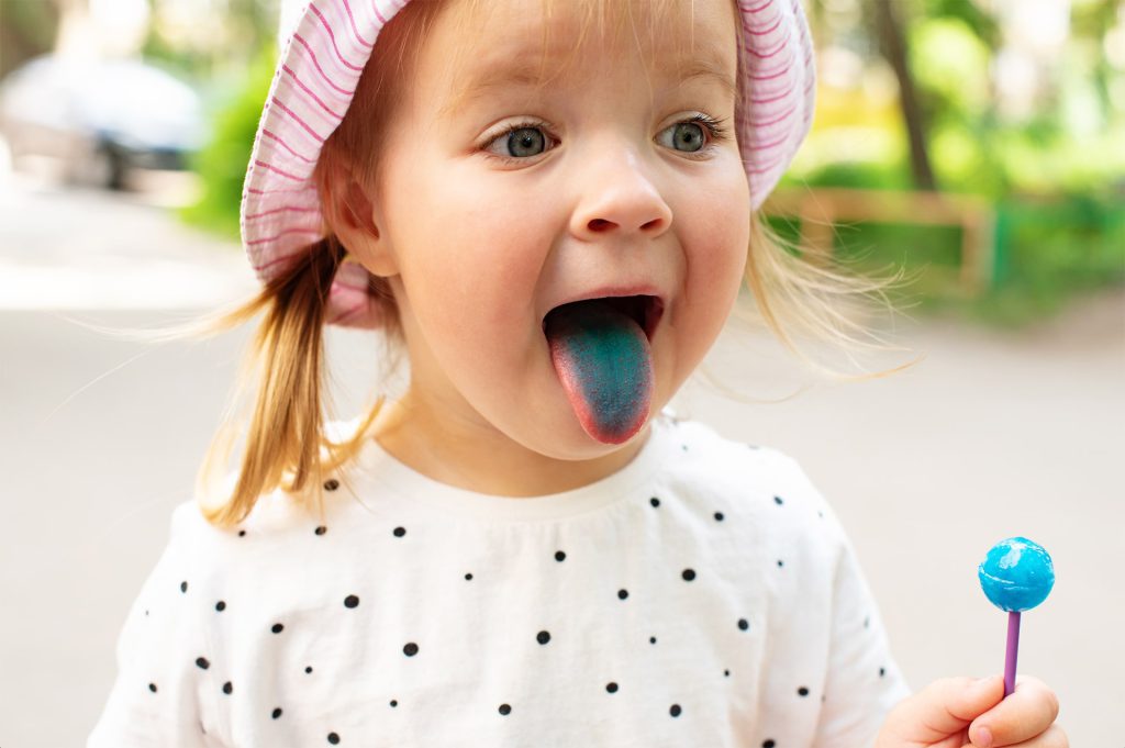 Colorante sintetico rilasciato da cibo sulla lingua di una bambina